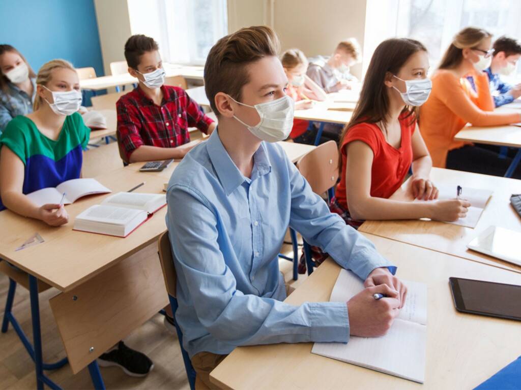 studenti classe ripartenza anno scolastico post covid con mascherine