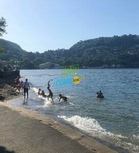 ragazzi fanno bagno nel lago dietro tempio voltiano anche se con cartelli di divieto