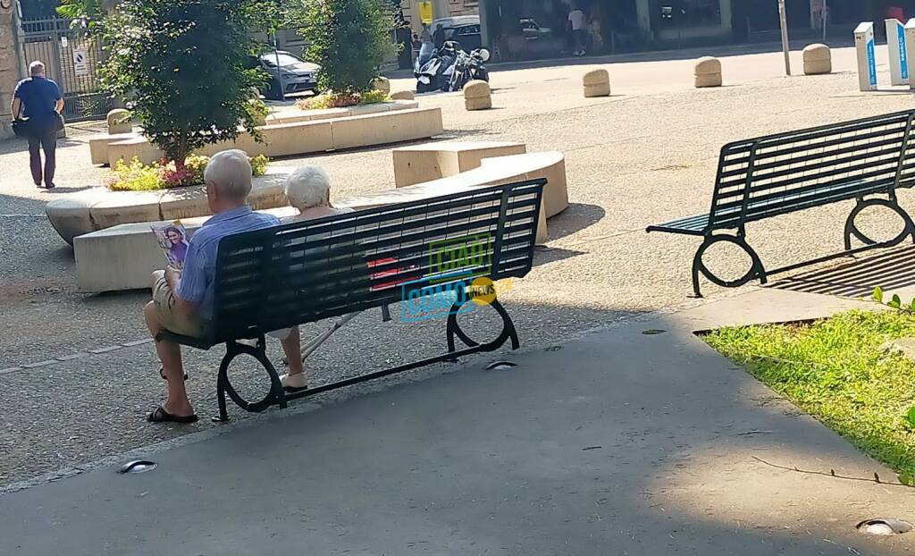 anziani in cerca di refrigerio per caldo e afa oggi como seduti su panchina